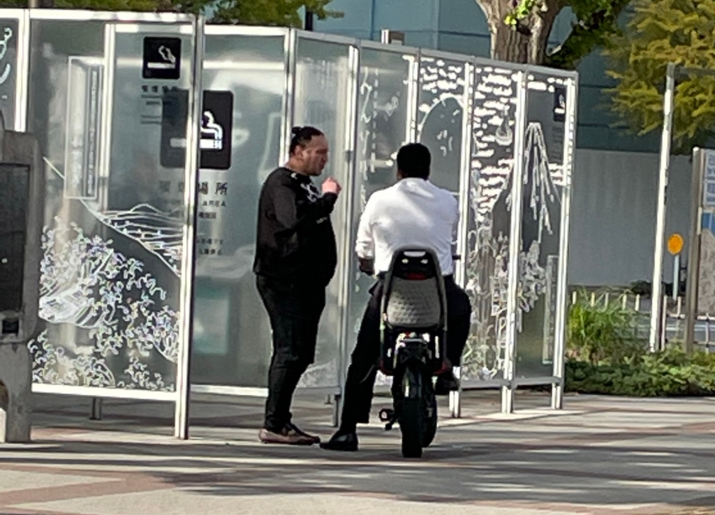 Tochinoshin talking with a cyclist. 